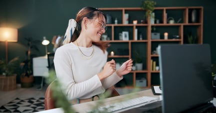 woman celebrating at computer after receiving reward