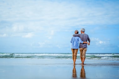 retired couple walking on the beach
