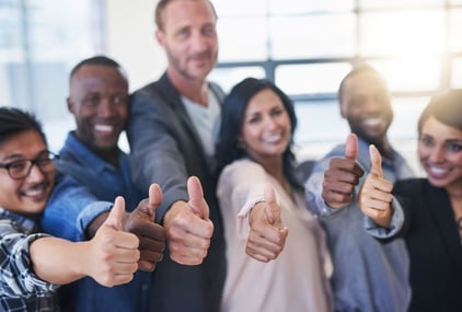 employees smiling and giving thumbs in an employee engagement survey