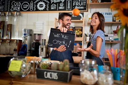 small business employee recognition man and woman hold an open sign